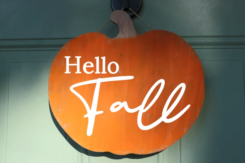 Hello fall. Hanging pumpkin shaped orange wooden sign.